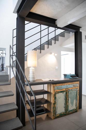 a room with a desk and a staircase with a lamp at Domu Qirat - Authentic Rooms & Terraces in Tortolì