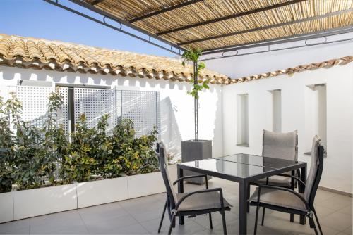 a black table and chairs on a balcony with plants at Domu Qirat - Authentic Rooms & Terraces in Tortolì