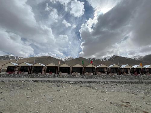 a row of tents with mountains in the background at Padma Cottage Pangong in Spangmik