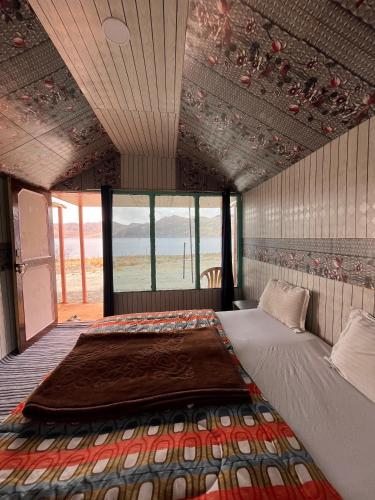 a bed in a room with a view of the ocean at Padma Cottage Pangong in Spangmik