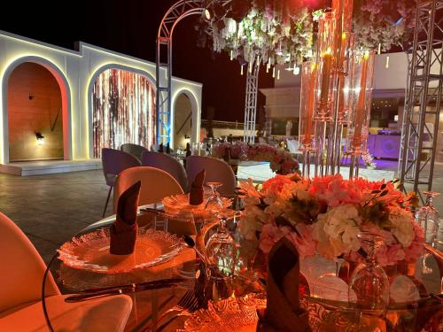 een eetkamer met een tafel met bloemen erop bij Lotus Hotel in Amman