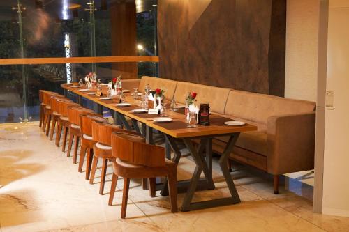 a long table in a restaurant with a long bench at Classic Regency in Alleppey