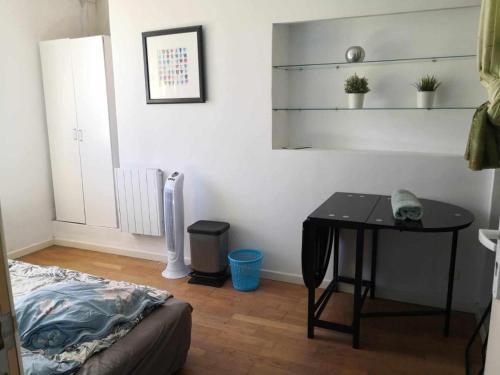 una camera con tavolo e letto e tavolo con telefono di Private room in an apartment of 3 rooms a Tolone