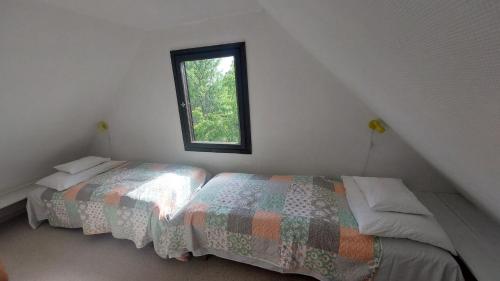 a bedroom with two beds and a window at Mandulás nyaraló in Zánka