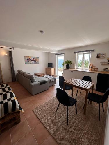 a living room with a couch and a table at Alcmaria studio with amazing views! in Folhadosa