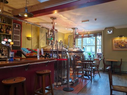 a bar with tables and chairs in a restaurant at The Old Cannon Brewery in Bury Saint Edmunds