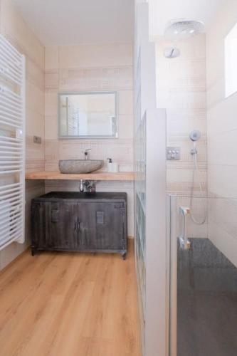 La salle de bains est pourvue d'un lavabo et de parquet. dans l'établissement La Suite Sablaise, à Les Sables-dʼOlonne