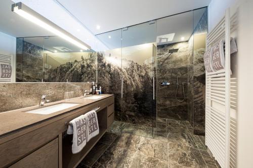 a bathroom with a sink and a shower at DAS GERSTL Alpine Retreat in Malles Venosta