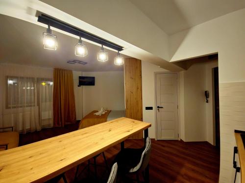 um quarto com uma mesa de madeira e algumas luzes em Central Nest Apartment em Brasov