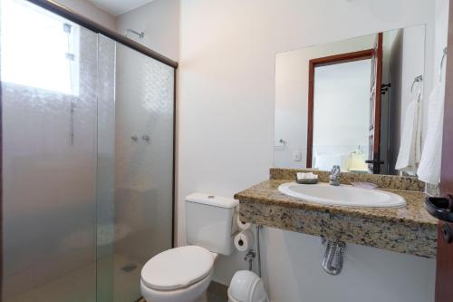 a bathroom with a toilet and a sink and a shower at Pousada do Timoneiro in Arraial do Cabo