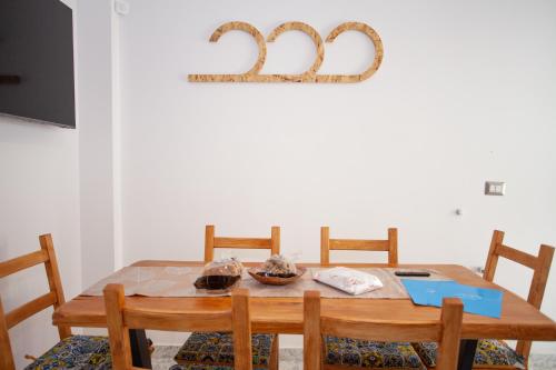 a dining room table with two chairs and a number on the wall at SeaBreeze Gallipoli - Lido San Giovanni in Gallipoli