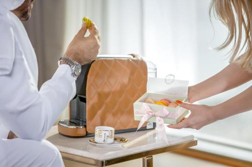 a woman is giving a man a box of fruit at Golden Sands Boutique Hotel-Dubai Creek in Dubai