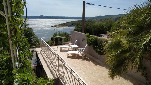 einen Balkon mit 2 Stühlen und Blick auf das Wasser in der Unterkunft Rustic Home Maslenica in Maslenica