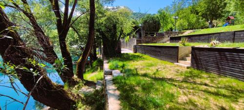 una pasarela con árboles y césped junto a una valla en Mila Holiday Home, en Lohovo