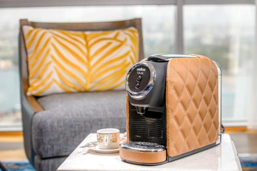 Golden Sands Boutique Hotel-Dubai Creek في دبي: آلة تحميص الخبز على طاولة مع كوب من القهوة