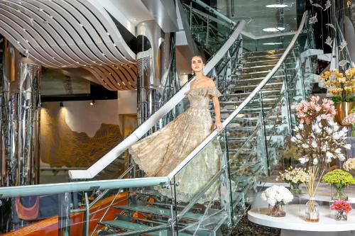 Eine Frau in einem Kleid auf einer Treppe in einem Gebäude in der Unterkunft Golden Sands Boutique Hotel-Dubai Creek in Dubai