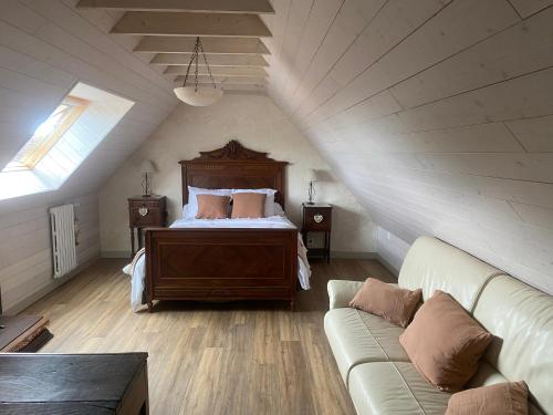 - une chambre mansardée avec un lit et un canapé dans l'établissement les gîtes de Blandines II, à Peumérit