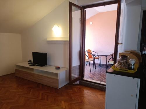 a living room with a television and a table with chairs at Rooms & Apartments Linda & Mario in Zadar