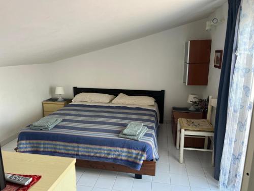 a bedroom with a bed with a blue and white blanket at Casa al mare con giardino vicino a Roma in Torvaianica