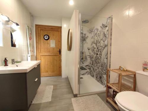 a bathroom with a shower and a sink and a toilet at La chaumière de jacquotte linge de lits en option in Limpiville