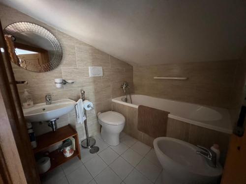 ein Badezimmer mit einem Waschbecken, einem WC und einer Badewanne in der Unterkunft Casa al mare con giardino vicino a Roma in Torvaianica