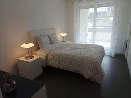 - une chambre avec un lit et deux lampes sur les tables dans l'établissement Sublime appartement au coeur de la Défense, à Courbevoie