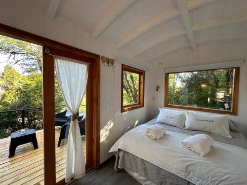 Mágica Tiny House con vista a la Montaña في سان مارتين دي لوس أندس: غرفة نوم بسرير وشرفة