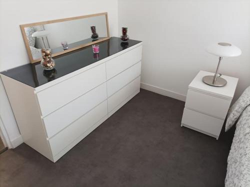 - une chambre avec une commode avec un miroir et un lit dans l'établissement Sublime appartement au coeur de la Défense, à Courbevoie
