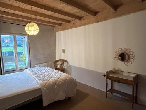 a bedroom with a bed and a table and a window at Gîte le clos Margherite 14 personnes piscine in Saint-Sorlin-de-Morestel