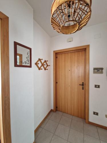 a hallway with a wooden door and a chandelier at Appartamenti Lido Riccio in Ortona