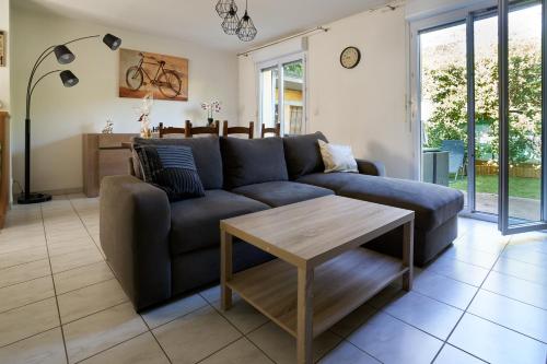 un salon avec un canapé bleu et une table dans l'établissement Maison climatisée, jardin , et parking privatif proche centre ville, à Avignon