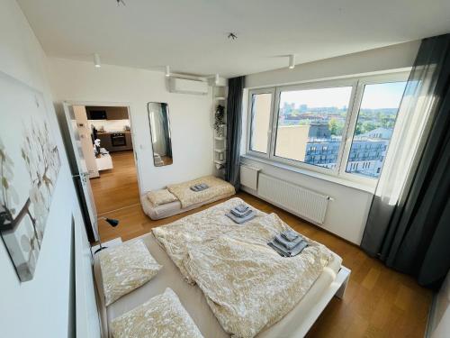 Cette chambre comprend deux lits et une grande fenêtre. dans l'établissement Brno City Center Apartment with parking and a big terrace, à Brno