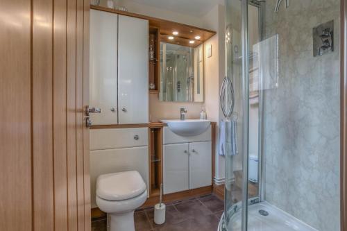 a bathroom with a toilet and a sink and a shower at Starfish Cottage, spacious Norfolk coastal house. - Crabpot Cottages Sheringham in Weybourne