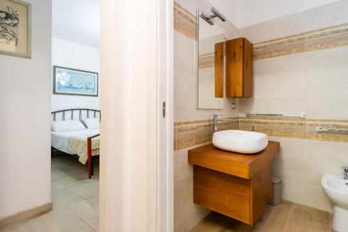 een badkamer met een wastafel, een toilet en een bed bij Guest House Eleonora by BarbarHouse in Alliste