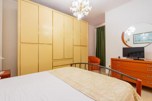 - une chambre avec un lit, une commode et une télévision dans l'établissement Guest House Eleonora by BarbarHouse, à Alliste