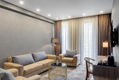 sala de estar con sofá, sillas y mesa en Vinum Hotel en Tiflis