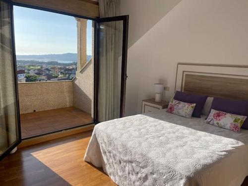 - une chambre avec un lit et une grande fenêtre dans l'établissement VILLA CON VISTAS AL MAR, à Sanxenxo