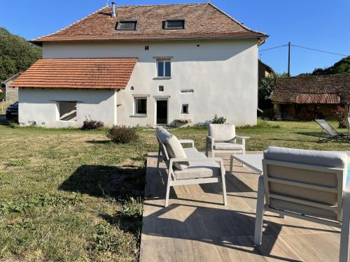 two chairs and a table in front of a house at Gîte le clos Margherite 14 personnes piscine in Saint-Sorlin-de-Morestel