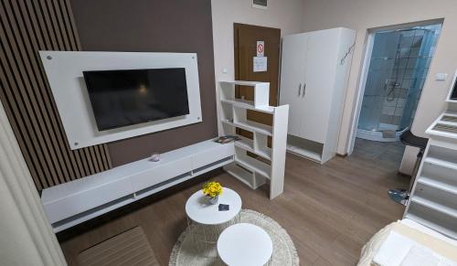 a living room with a television and a white table at Apartmani Tomić in Kladovo