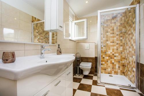 een badkamer met een wastafel, een toilet en een douche bij Villa Valerija in Srinjine