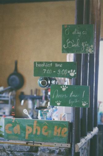 a group of green signs on a wall at Maison de Hill Home in Dồng Văn