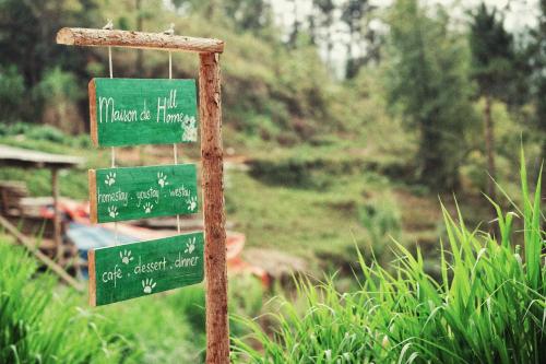 a pole with green street signs in a field at Maison de Hill Home in Dồng Văn