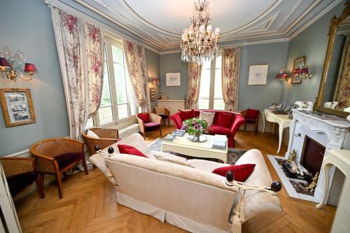 un salon avec un canapé et une cheminée dans l'établissement Château de la Chaix, à Saint-Christophe-en-Brionnais