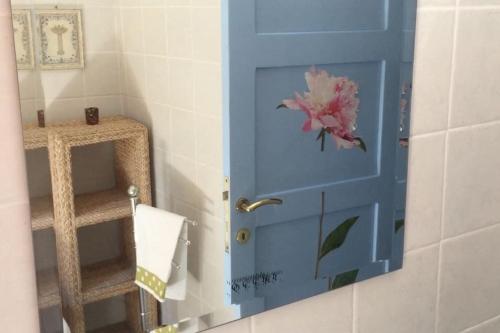 eine blaue Tür mit einer Blume darauf in einem Badezimmer in der Unterkunft Kos Guest House with patio and garden in Antimácheia