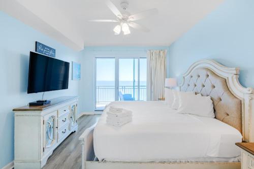 een slaapkamer met een wit bed en een flatscreen-tv bij Legacy I 902 in Gulfport