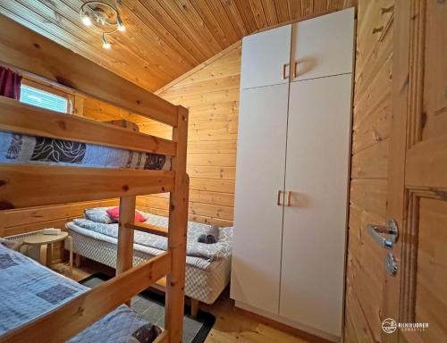 a bedroom with bunk beds in a log cabin at Lomariihi 8 in Muurame