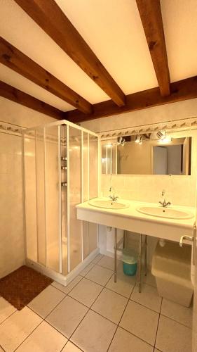 une salle de bain avec deux lavabos et une douche dans l'établissement Jolie maison de vacances avec terrasse et jardin, à Saint-Julien-en-Born