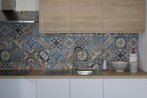 a kitchen with a sink and tiles on the wall at IL CORTILE DELLE ZAGARE in Pollica