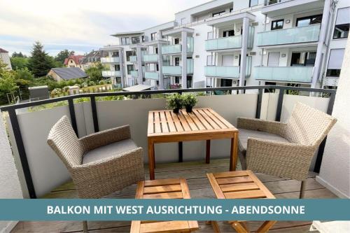 einen Balkon mit einem Holztisch und Stühlen in der Unterkunft Semper Suite No2 - Ruhige 2 Zi FeWo 1-4 Pers mit Küche, Duschbad, Balkon und Parkplatz in Hofgartennähe in Bayreuth
