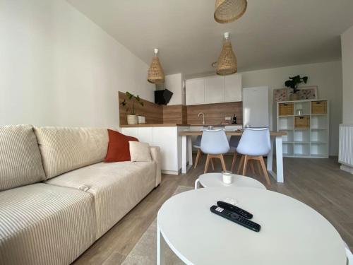 un salon avec un canapé et une table et une cuisine dans l'établissement Appartement - Visitez Paris, à Aubervilliers